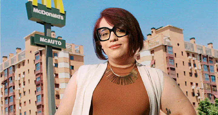 mujer con gafas en frente de edificio Mcdonalds