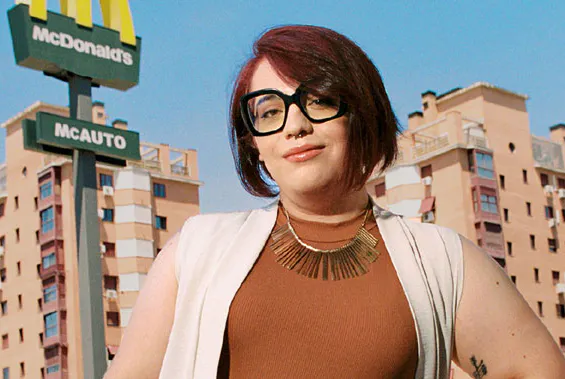 mujer con gafas en frente de edificio Mcdonalds