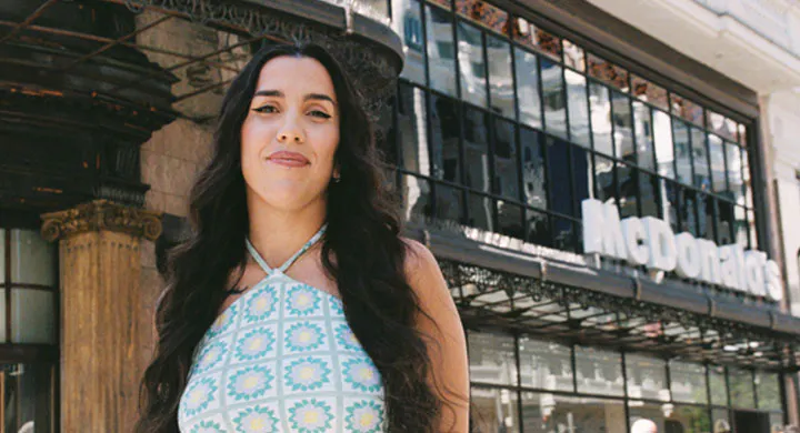 mujer con vestido azul en frente de edificio