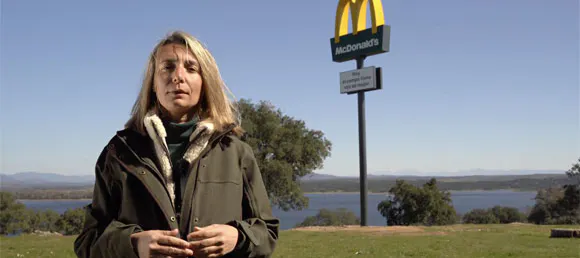 mujer en el campo con logo de McDonald's detrás