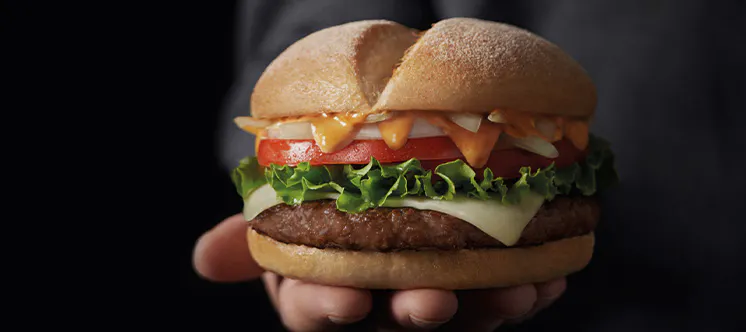 Un home amb vestit subjectant una hamburgueses