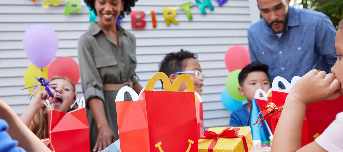 Haurrak patioan urtebetetzea ospatzen Happy Meals-ekin