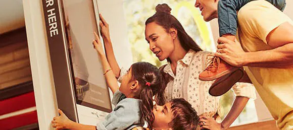 Família completant la comanda en una pantalla tàctil