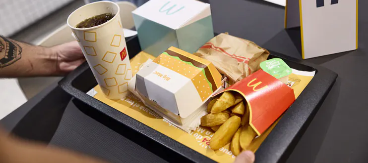 Uns braços sostenint una safata amb un menú de McDonalds
