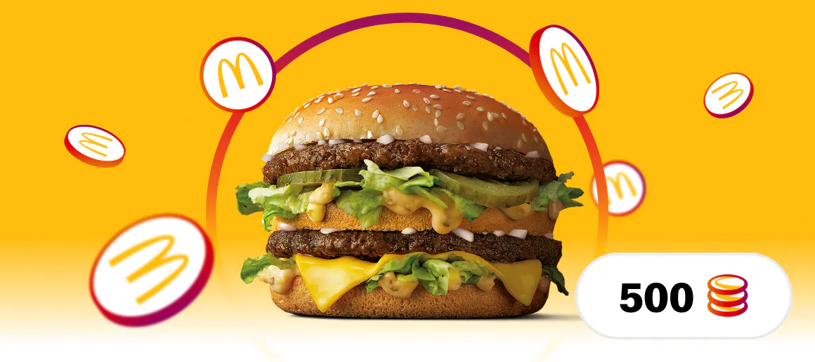 Big Mac hanburgesa hondo horian McDonald's logoa inguruan erortzen duten txanponekin. Beheko eskuinaldean, 500 puntukoa dela adierazten duen testua duen tarte bat dago.