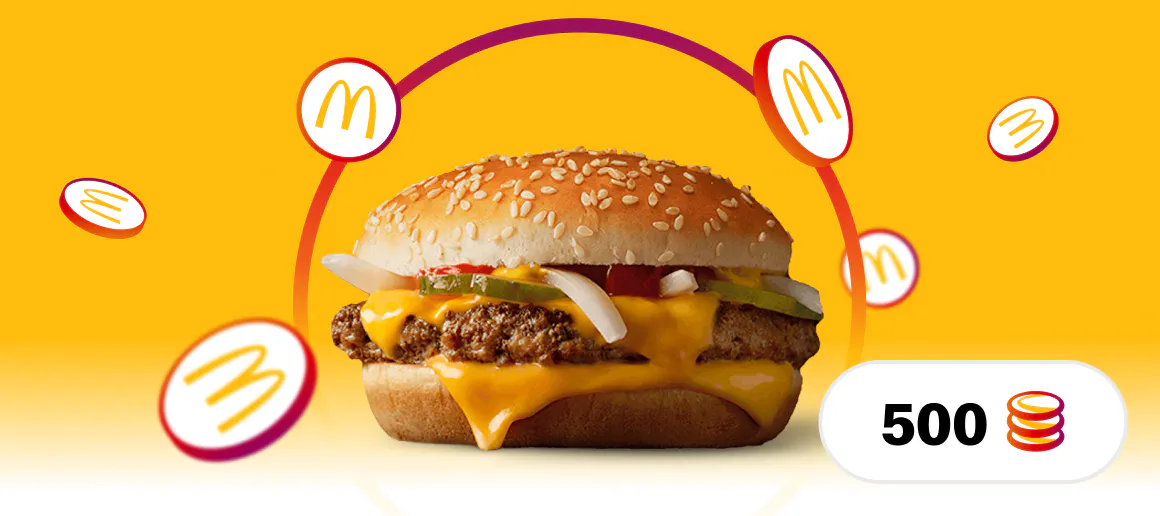 Imagen de una hamburguesa McDonalds cuarto de libra situada en un fondo amarillo con monedas con el logo de MyMcDonalds alrededor y un icono abajo a la derecha con el numero 500 y un icono de monedas